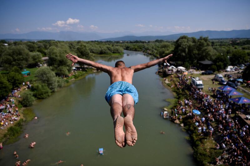 A man jumps from the 22-metres high bridge Ura e Shenjte during the annual traditional High Diving competition near the town of Gjakova, Kosovo.  AFP