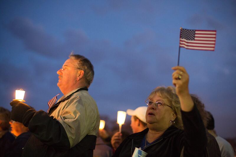 Mourners hold candles and U.S. flags during a vigil for Martin Richard, one of three killed in the Boston Marathon bombings, at Garvey Park in Boston, Massachusetts, U.S., on Tuesday, April 16, 2013. Richard, an 8-year-old from Boston's Dorchster neighborhood, was among the dead in blasts that also injured his mother and sister. Photographer: Scott Eisen/Bloomberg *** Local Caption ***  1201333.jpg