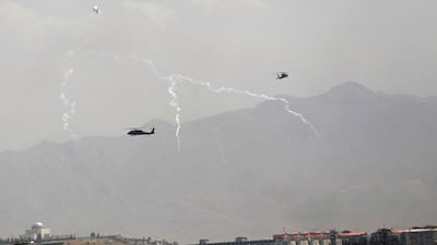 Anti-missile decoy flares are fired as US Black Hawk military helicopters and an airship fly over Kabul, Afghanistan, on August 15. AP