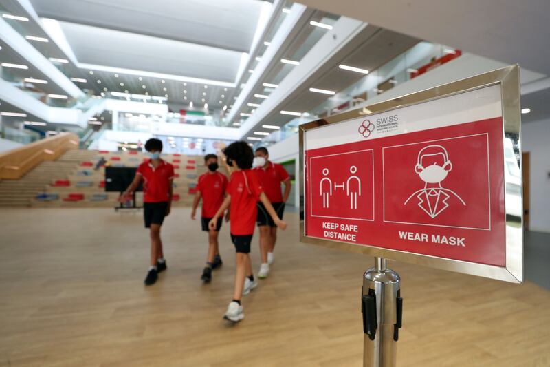 Signs reminding people to wear a mask, such as this one at the Swiss International Scientific School in Dubai, have been removed in most places. Chris Whiteoak / The National