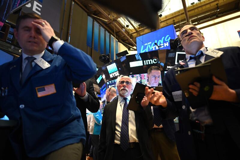 Traders work during the opening bell at the New York Stock Exchange (NYSE) at Wall Street in New York City. Trading on Wall Street was halted immediately after the opening bell Monday, as stocks posted steep losses following emergency moves by the Federal Reserve to try to avert a recession. AFP