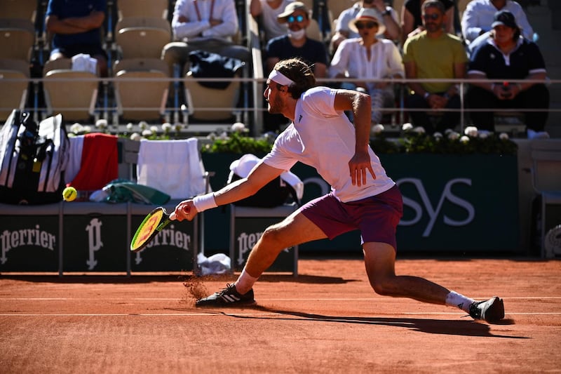 Stefanos Tsitsipas slides to retrieve a drop shot during the French Open final. AFP