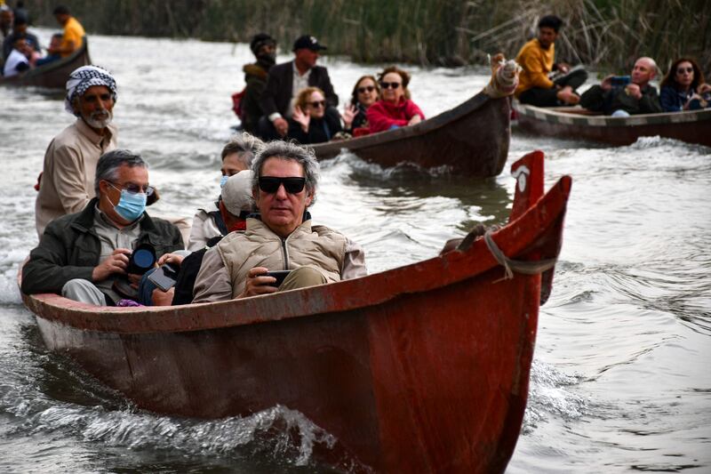 Spanish visitors to the Marshes of Jabayesh in southern Iraq tour the area by boat.