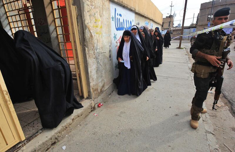 A member of the Iraqi security forces stands guard as women queue in front of a polling station in the Wadi Hajar district of Mosul. Ahmad Al Rubaye / AFP