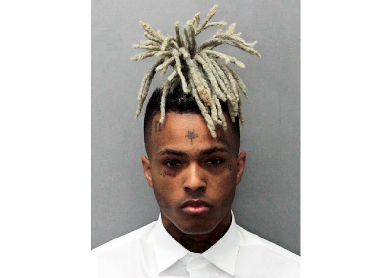 This undated mugshot released by the Miami- Dade Corrections & Rehabilitation Department shows rapper XXXTentacion. Authorities say troubled rapper-singer XXXtentacion has been fatally shot in Florida. The Broward Sheriff's Office says the 20-year-old rising star was pronounced dead Monday, June 18, 2018 at a Fort Lauderdale-area hospital. He was shot earlier outside a Deerfield Beach motorcycle dealership. (Miami- Dade Corrections & Rehabilitation Department via AP)