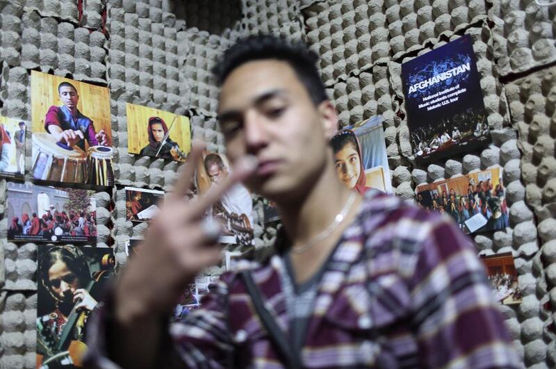 Afghan rapper Mahmoud Hejran shows his band’s symbol at his apartment, which is used as a music studio.