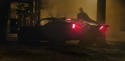 Robert Pattinson as Batman with the Batmobile in a scene from 'The Batman'. Photo: Warner Bros. Pictures 