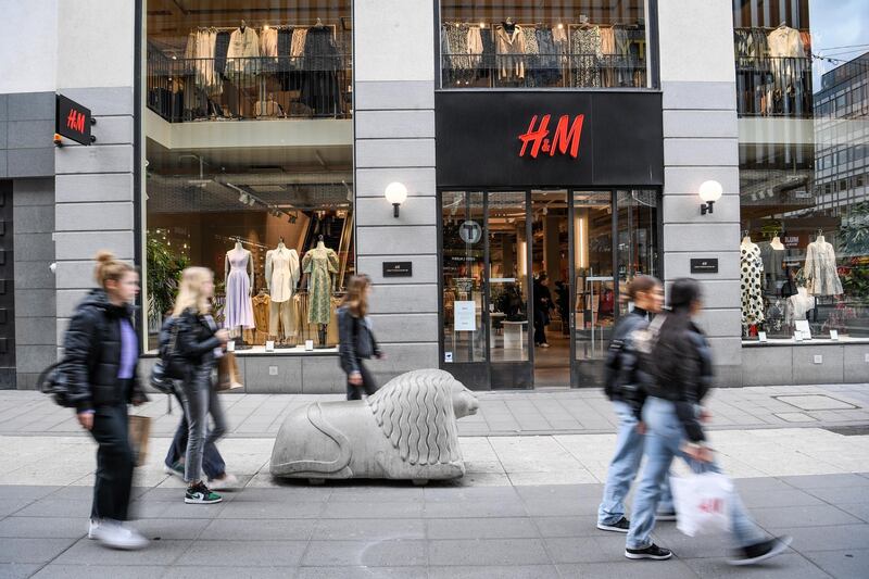 Shoppers pass an H&M shop in central Stockholm, Sweden, on April 2, 2020. The retailer has started dialogue with with tens of thousands of staff about cutting working hours due to the coronavirus pandemic's effect on the market. EPA