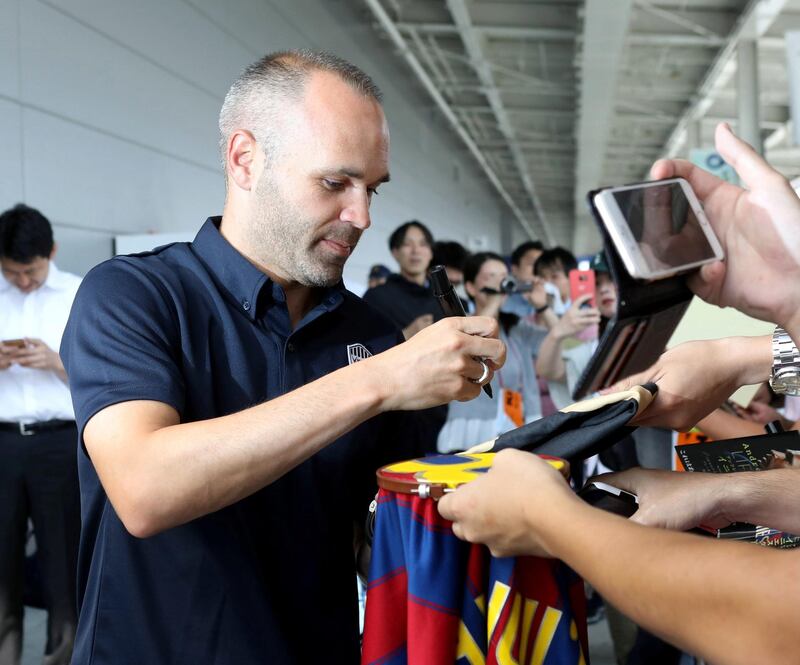 Iniesta signs his autograph for Japanese fans upon his arrival at Kansai International Airport. Jiji Press / EPA