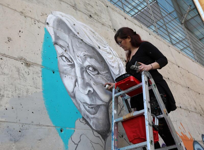 Lebanese artist Roula Abdo paints a portrait of the late Egyptian writer and feminist Nawal El Saadawi in Beirut at an event to commemorate her life. AFP