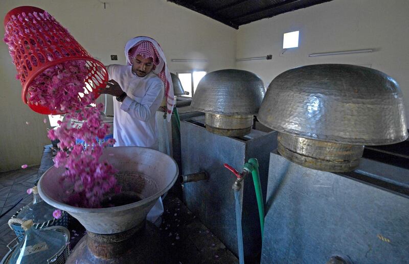 Salman pours weighed roses into a copper vat ahead of the distillation process. AFP