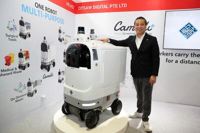Ling Ting Ming, founder and chief executive of OTSAW, with the multipurpose robot at the Singapore stand at Arab Health 2024 in Dubai. Pawan Singh / The National