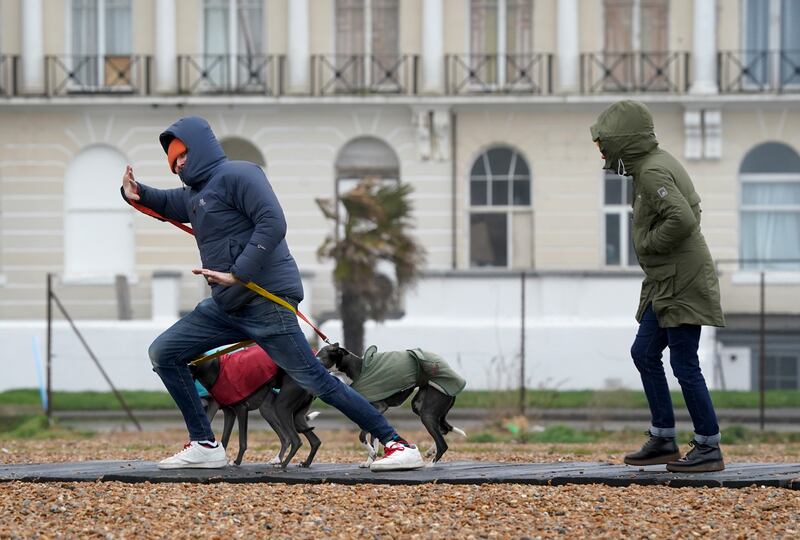 Friday morning brought wet and windy weather to the south of England, with a couple of dog walkers struggling against strong winds in Folkestone, Kent. PA