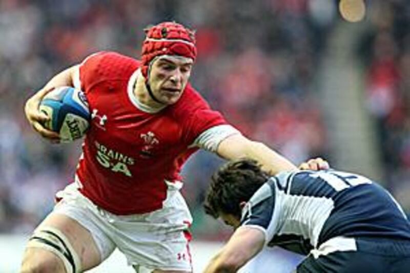 Alun-Wyn Jones, left, hands off a tackle by Hugo Southwell in Wales commanding 26-13 victory at Murrayfield.