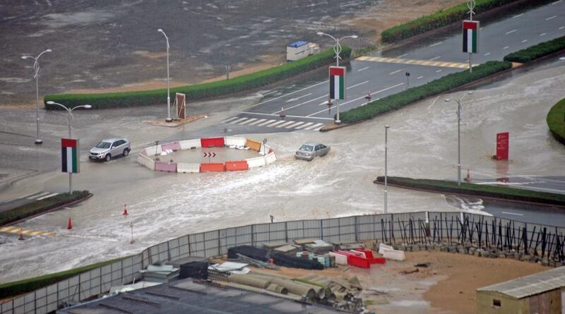 Cars splash through a flooded roundabout at Sports City, Dubai. Courtesy David A Dunn