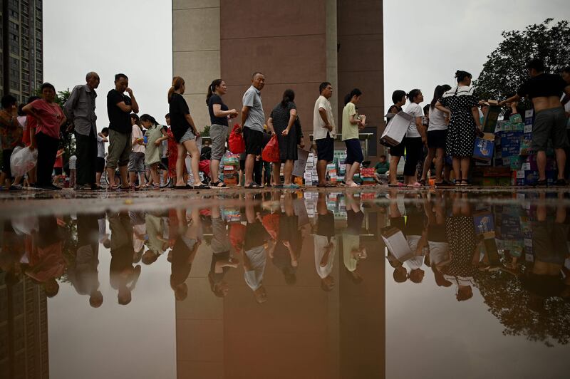 People queue to receive relief goods following a heavy rain in Zhengzhou, in China's Henan province.