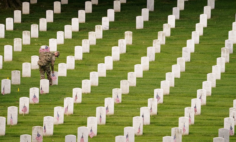 A soldier of the third US Infantry Regiment, or Old Guard, places flags on headstones before Memorial Day, at Arlington National Cemetery, in Arlington, Virginia. During an annual ceremony, over 1,000 Old Guard soldiers place small American flags at more than 260,000 headstones at the cemetery. Reuters
