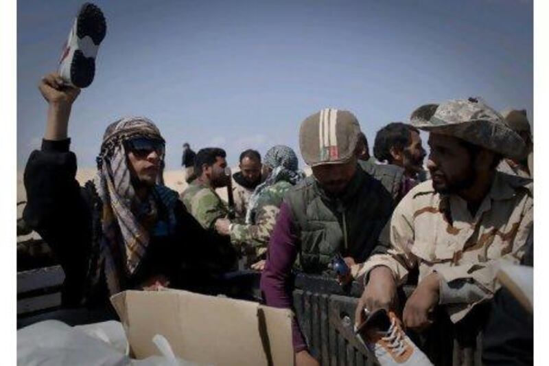 Sneakers are handed out to Libyan rebels on a checkpoint on the frontline near the outskirts of Ajdabiya, south of Benghazi.