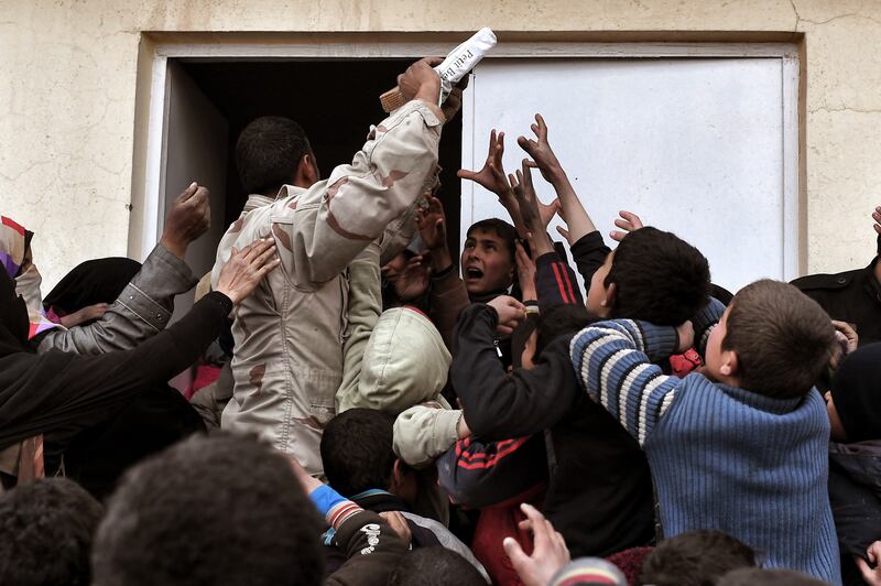 An Iraqi soldier delivers aid to displaced residents of Mosul.