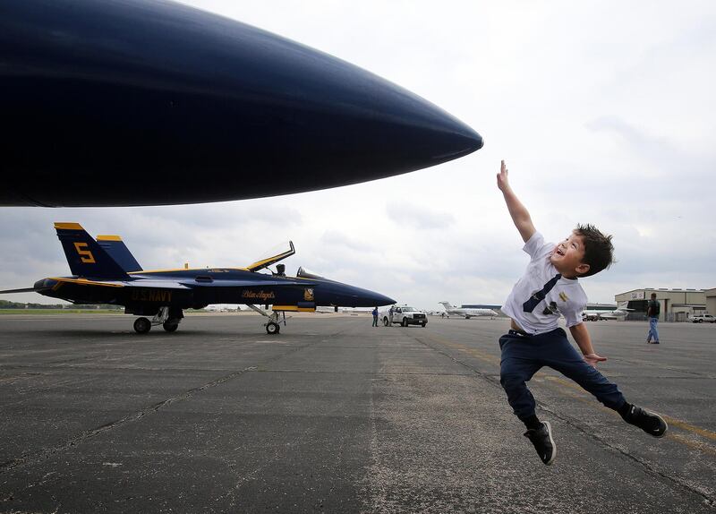 A US youngster, tries to touch the nose cone of a Hornet Blue Angel plane in Waco, Texas. AP