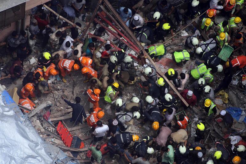 Rescuers work at the site of a building. AP Photo