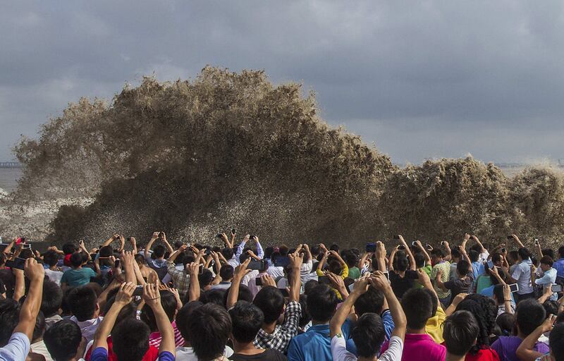 Visitors take pictures of tidal waves during Typhoon Usagi in Hangzhou, Zhejiang province, China. Chance Chan / Reuters



