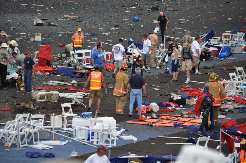 A crowd gathers around debris after a P-51 Mustang airplane crashed at the Reno Air show on Friday, Sept. 16, 2011 in Reno Nev.. The plane plunged into the stands at the event in what an official described as a "mass casualty situation." (AP Photo/Grass Valley Union, Tim O'Brien) MANDATORY CREDIT *** Local Caption ***  Air Show Crash.JPEG-0d09e.jpg