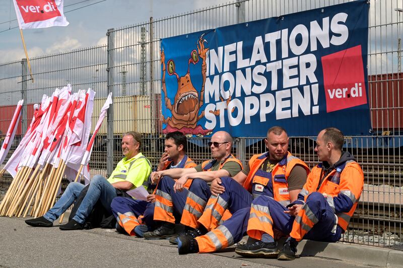 Workers sit in front of a banner reading "Stop the Inflation Monster" at the Burchardkai Container Terminal as they go on strike for higher wages at the harbour in Hamburg, Germany. Reuters