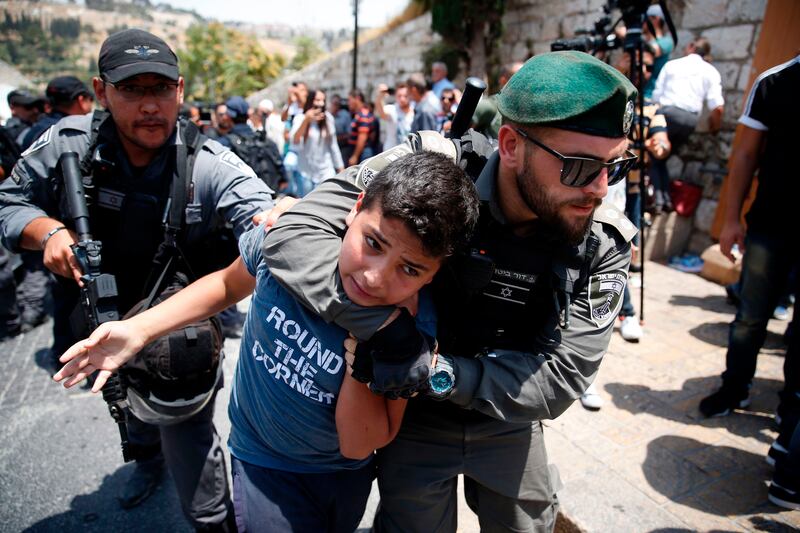 Israeli border guards detain a Palestinian youth during a demonstration outside the Lions Gate, a main entrance to Al-Aqsa mosque compound, due to newly-implemented security measures by Israeli authorities which include metal detectors and cameras, in Jerusalem's Old City on July 17, 2017.
Israel reopened the ultra-sensitive holy site, after it was closed following an attack by Arab Israeli men in which two Israeli policemen were killed. / AFP PHOTO / AHMAD GHARABLI