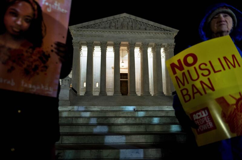 Activists protest the travel ban outside the US Supreme Court December 7, 2017 in Washington, DC.
Three versions of President Donald Trump's travel ban -- the most controversial of his executive orders -- were successfully blocked by the courts, before the Supreme Court allowed the third to take affect this week, pending appeals. / AFP PHOTO / Brendan Smialowski