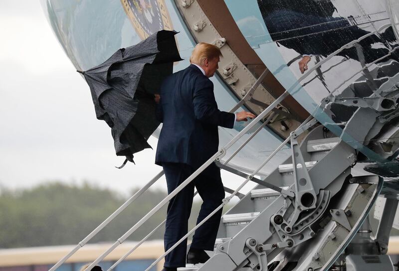 U.S. President Donald Trump folds his umbrella while boarding Air Force One before departing from Glasgow, Scotland, on his way to Helsinki, Finland, Sunday, July 15, 2018, on the eve of his meeting with Russian President Vladimir Putin. (AP Photo/Pablo Martinez Monsivais)