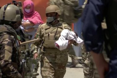 Afghan security personnel move a baby from a hospital, where Doctors Without Borders runs a maternity clinic, that was attacked in Kabul. Reuters