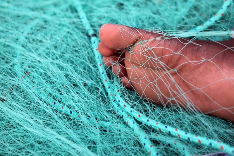 August 15, 2011 (Umm al Quwain) Shankar Shanmuganathan from India fixes a fishing net just before sunset in Umm al Quwain August 15, 2011. (Sammy Dallal / The National)