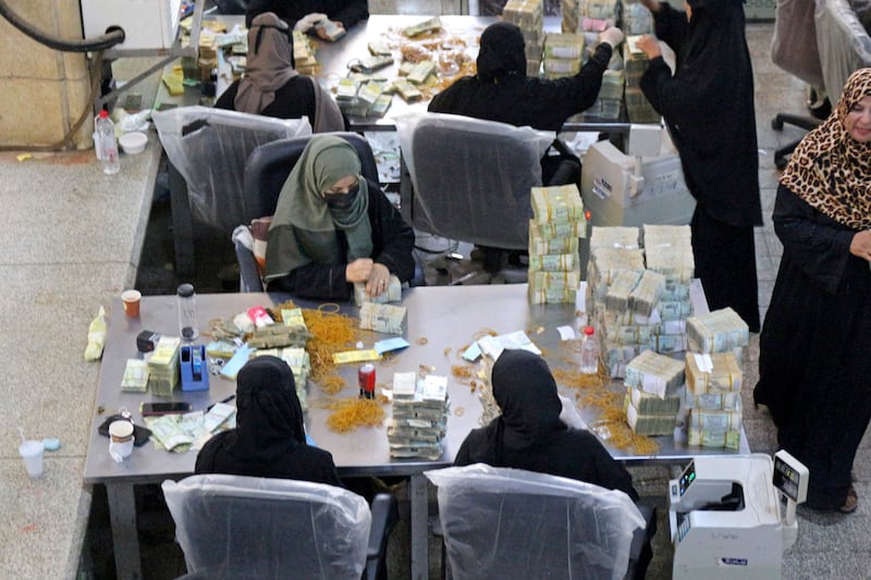 Employees count stacks of Yemeni currency at the central bank in the southern port city of Aden. AFP