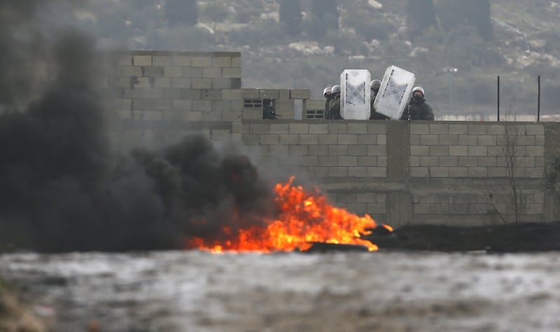 Israeli troops shelter behind shields during confrontations with Palestinian protesters. EPA