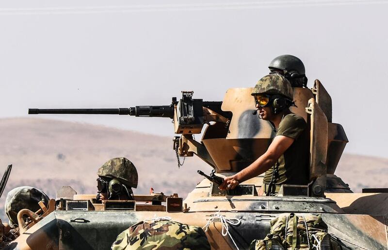 Turkish soldiers look across the border into Syria. Ankara has sent ground troops to stop Kurdish ambitions on its border (AFP / Bulent Kilic)