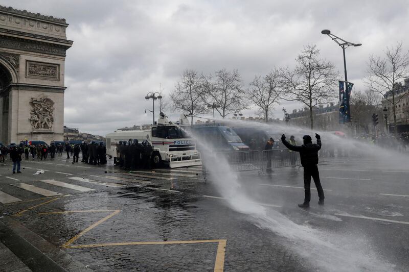 A protester gestures at riot police on the Champs-Elysees on March 16, 2019. AFP