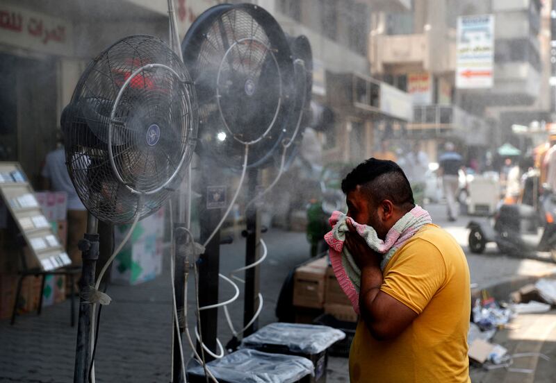 Fans spraying air mixed with water vapour cool pedestrians on a street in Iraq's capital, Baghdad, during a severe heat wave.