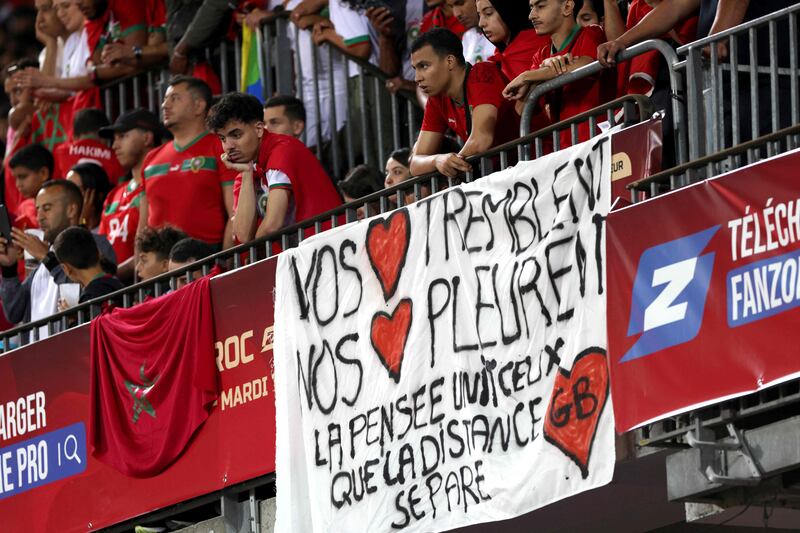 Football fans display a sign with a message of support for those affected by the earthquake in Morocco during a match between Morocco and Burkina Faso in Lens, France. AFP