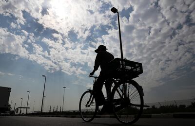 ABU DHABI , UNITED ARAB EMIRATES ,  October 18 , 2018 :- One of the delivery man on his cycle during the cloudy day near the Deerfields mall in Abu Dhabi. ( Pawan Singh / The National )  For Standalone/Instagram