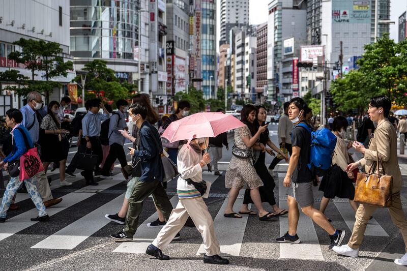 Pedestrians cross a street in the Shinjuku district of Tokyo. AFP