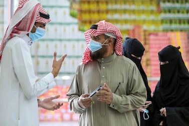 A man displays his details on his mobile phone using an app launched by Saudi authorities to track people infected with the coronavirus disease. A new survey by global recruitment consultancy Hays found 53% of employers and 56% of employees in the kingdom expect salaries to increase in 2021. Reuters