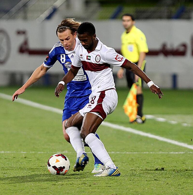 Eisa Ahmed, right, of Al Wahda tussles for the ball with Brett Holman of Al Nasr during their Arabian Gulf League match on January 6, 2014. Satish Kumar / The National