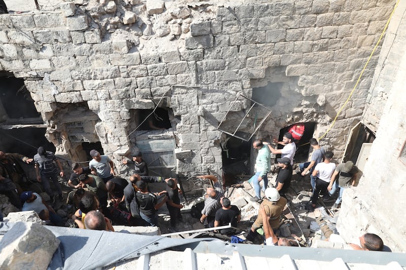 Palestinians search a house to retrieve the bodies of three Palestinians killed by Israeli troops during a raid in the West Bank city of Nablus.  EPA