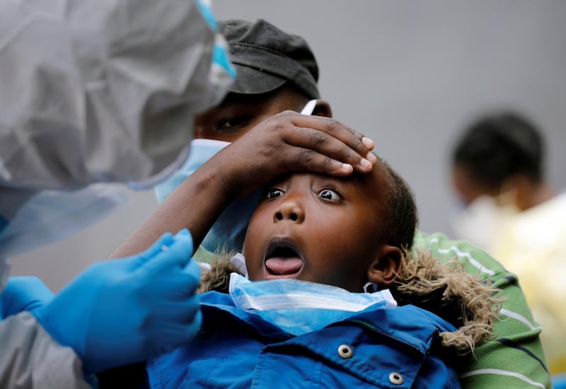 A young girl reacts as a Kenyan ministry of health medical worker takes a swab during mass tasting in an effort to fight against the spread of the coronavirus disease in the Kawangware neighbourhood of Nairobi, Kenya. Reuters