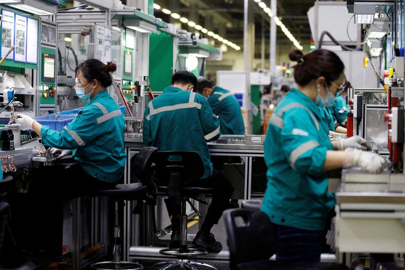 Employees work on the production line in a Schneider Electric factory in Beijing. Manufacturing activity in China fell for the fourth month in a row in July, causing oil prices to trade slightly lower on Tuesday. Reuters