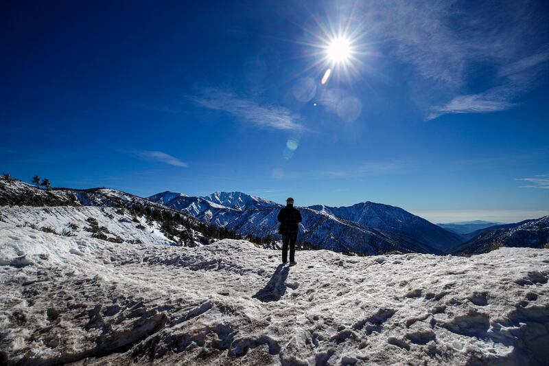 John Dedman enjoys the view of snow-covered mountains along Highway 2 near Inspiration Point in Wrightwood, California.