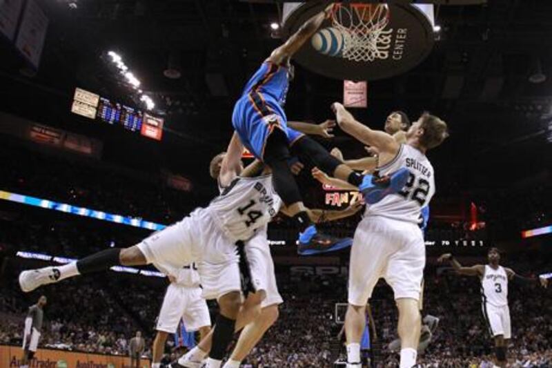 SAN ANTONIO, TX - MAY 29: Russell Westbrook #0 of the Oklahoma City Thunder goes up to dunk the ball against Gary Neal #14 and Tiago Splitter #22 of the San Antonio Spurs in the second half in Game Two of the Western Conference Finals of the 2012 NBA Playoffs at AT&T Center on May 29, 2012 in San Antonio, Texas. NOTE TO USER: User expressly acknowledges and agrees that, by downloading and or using this photograph, user is consenting to the terms and conditions of the Getty Images License Agreement.   Ronald Martinez/Getty Images/AFP== FOR NEWSPAPERS, INTERNET, TELCOS & TELEVISION USE ONLY ==

