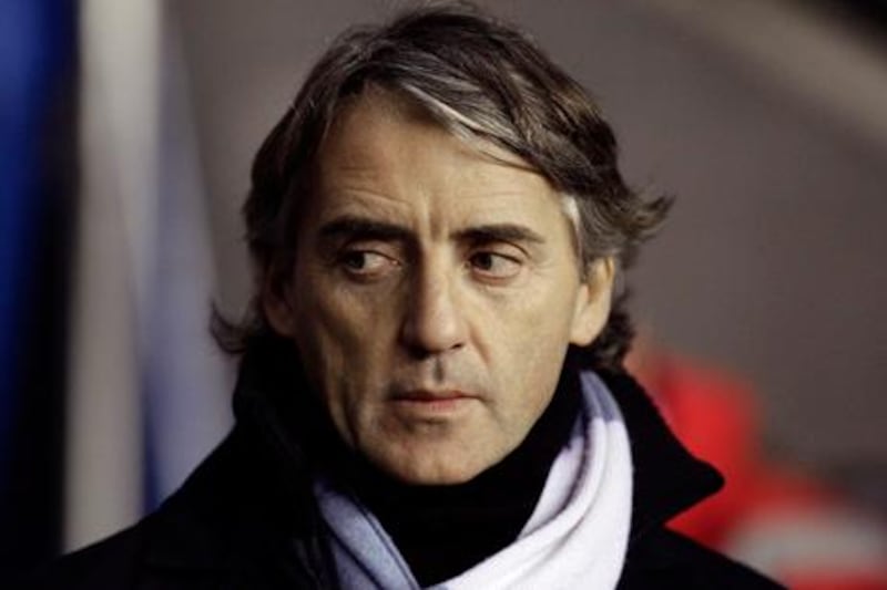 Manchester City's manager Roberto Mancini takes to the touchline before his team's English Premier League soccer match against Wigan Athletic at The DW Stadium, Wigan, England, Monday Jan. 16, 2012. (AP Photo/Jon Super) 