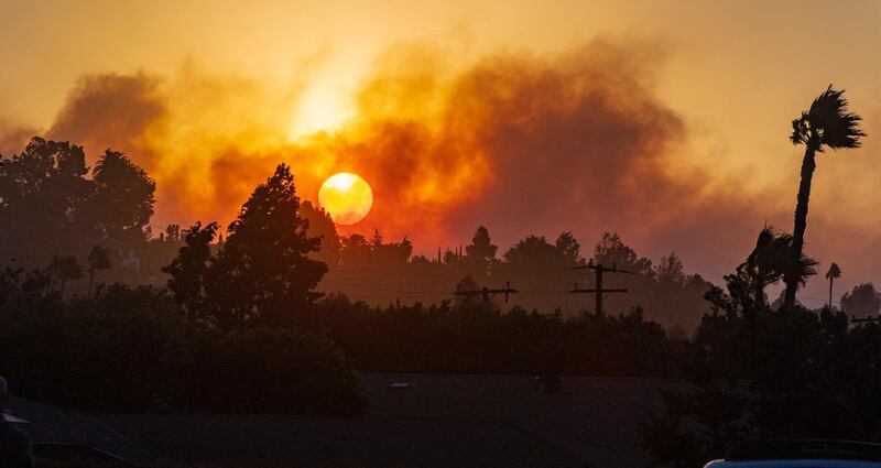 The morning sun rises through the smoke of fire in the canyons east of North Tustin on Monday, October 26, 2020. Firefighters were aggressively battling a vegetation fire that broke out in the hills near Silverado in Orange County as strong wind gusts pushed it. Mark Rightmire/The Orange County Register via AP